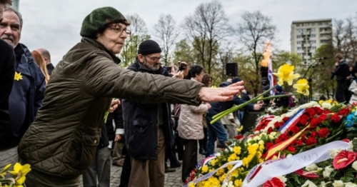 une-femme-depose-des-jonquilles-devant-le-monument-deposent-des-fleurs-devant-le-monument-aux-heros-du-ghetto-le-19-avril-2016-a-varsovie-en-pologne.jpg